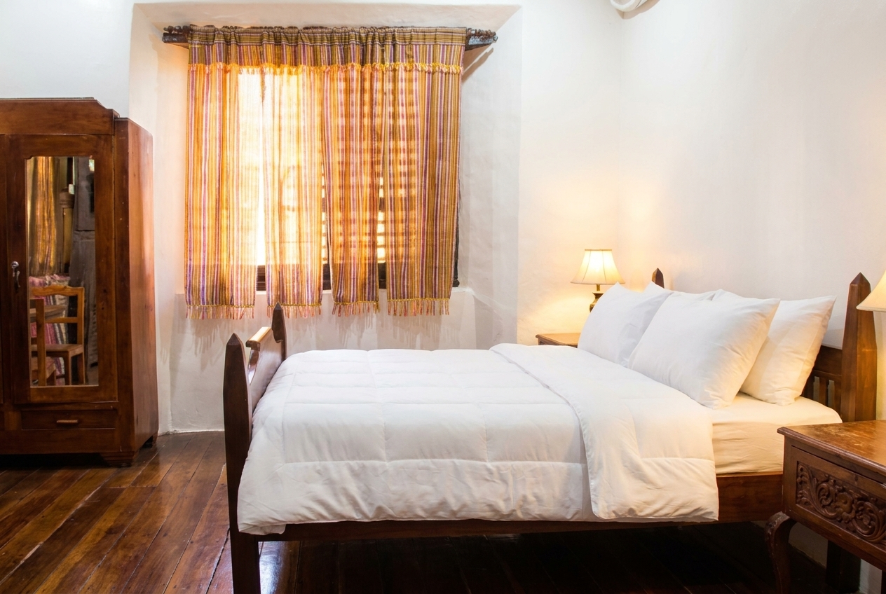 Standard Room with carved wooden bed frame at Casa de Gabriela