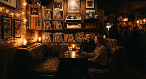 Leather listening booth under amber lamps with vinyl crates along the wall.