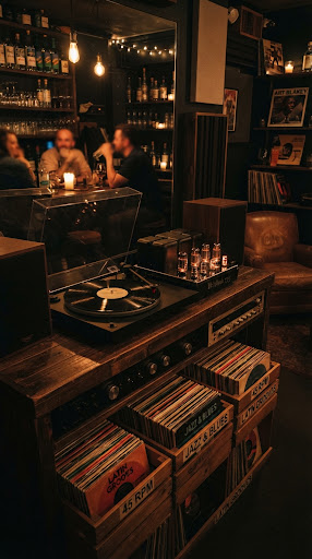 The sound bar at dusk: wooden crates of 45s, glowing tube amps, and a turntable mid-spin.