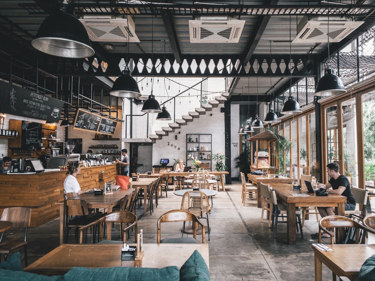 High-ceiling dining room with long wooden tables