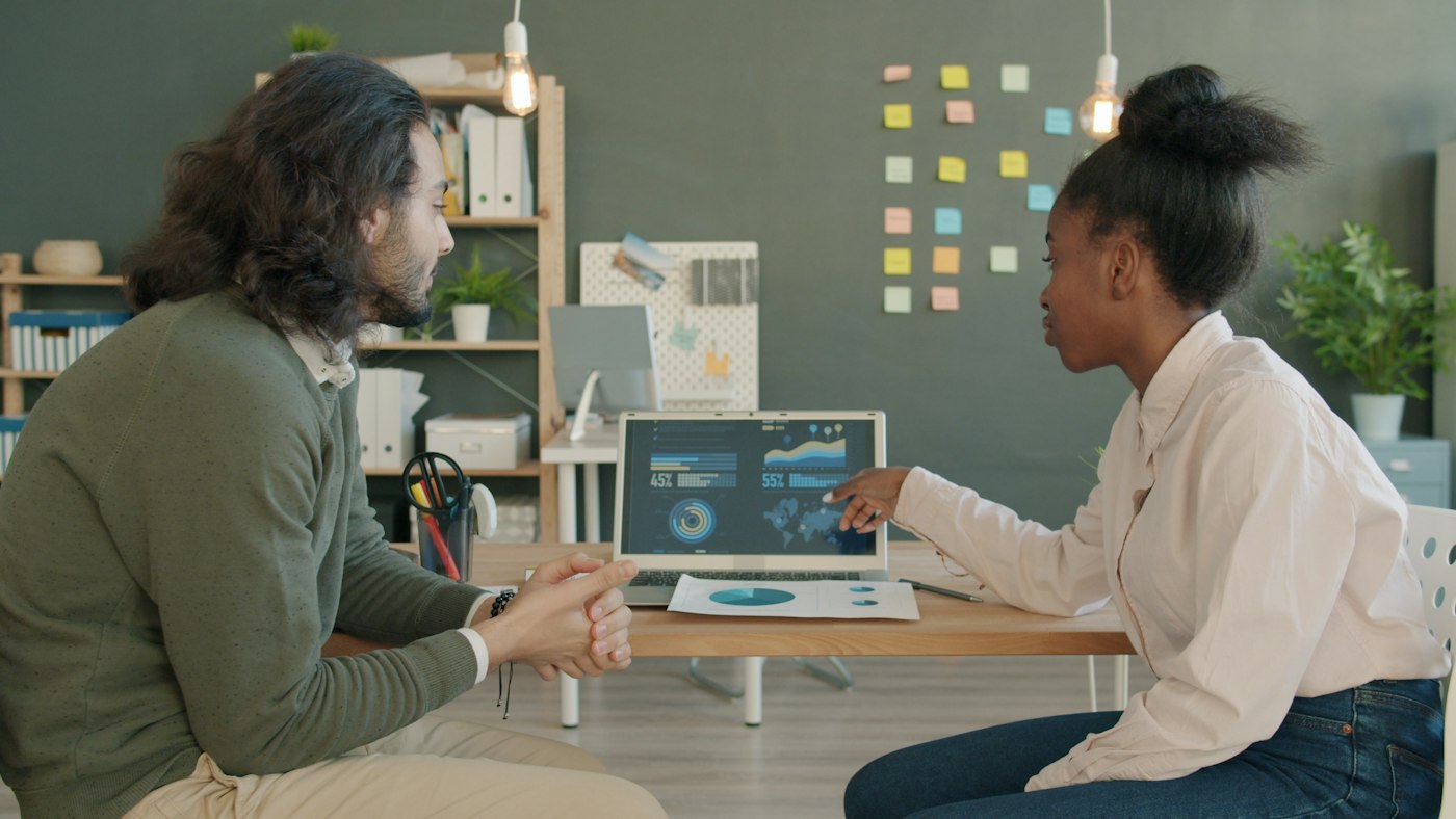 A student and mentor reviewing a dashboard together on a laptop