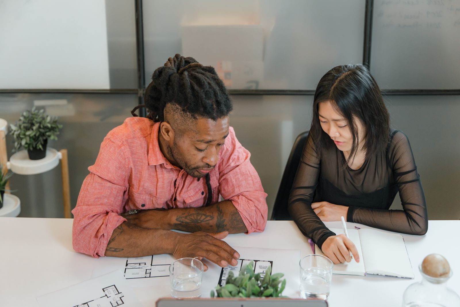 Two colleagues reviewing payslip paperwork at a desk